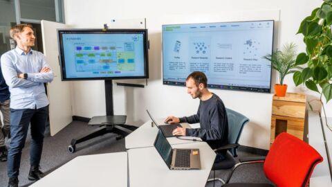 Zwei Personen befinden sich vor Moitoren.