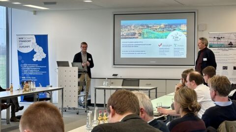 Zwei Männer halten einen Vortrag in einem Konferenzraum